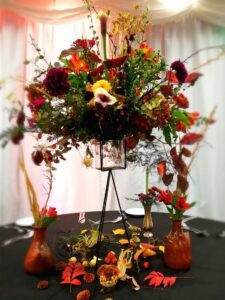 Orange and burgundy autumnal floral table centrepiece